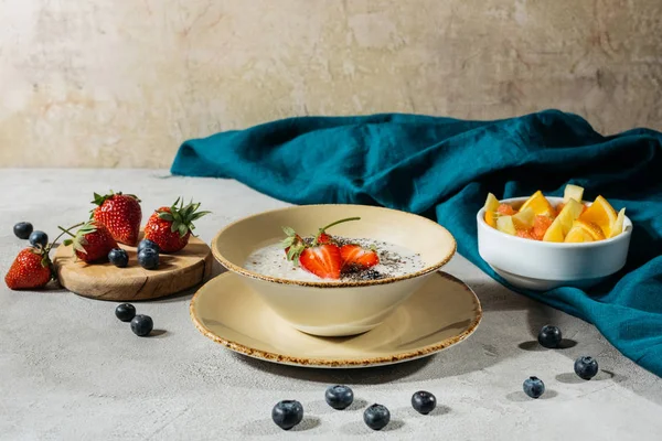 Desayuno saludable con un bol de semillas de chía y frutas maduras en la mesa con mantel - foto de stock