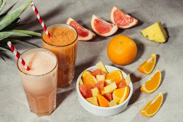 Очки с натуральным соком и спелыми тропическими фруктами на столе — стоковое фото