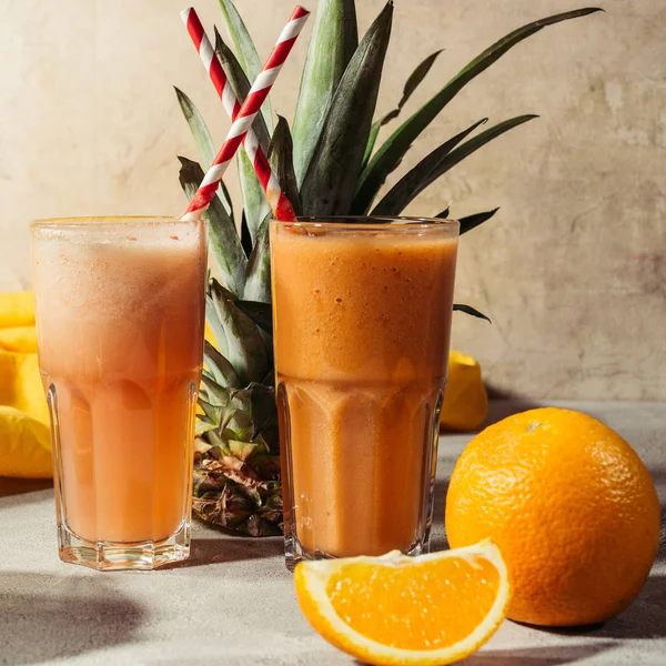 Fruits tropicaux et verres avec jus sur la table — Photo de stock