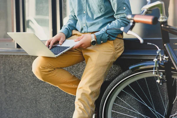 Обрезанный снимок человека с помощью ноутбука снаружи здания — стоковое фото
