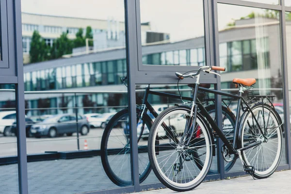Stilvolles Fahrrad spiegelt sich in modernem Gebäude an leerer Straße wider — Stockfoto
