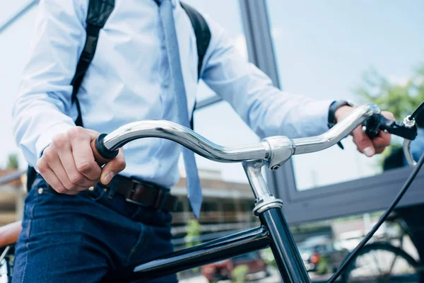 Cropped shot of young businessman riding bicycle — Stock Photo