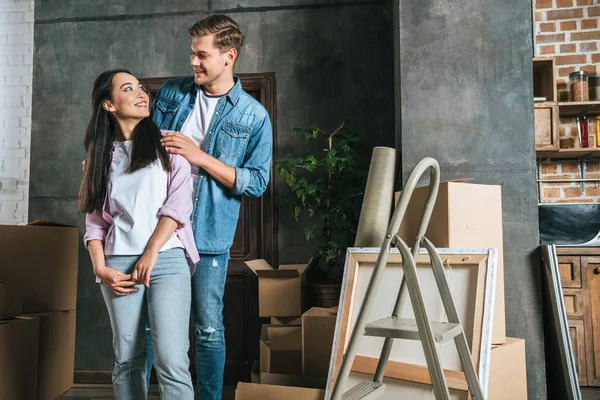 Smiling interracial couple with boxes moving into new home — Stock Photo