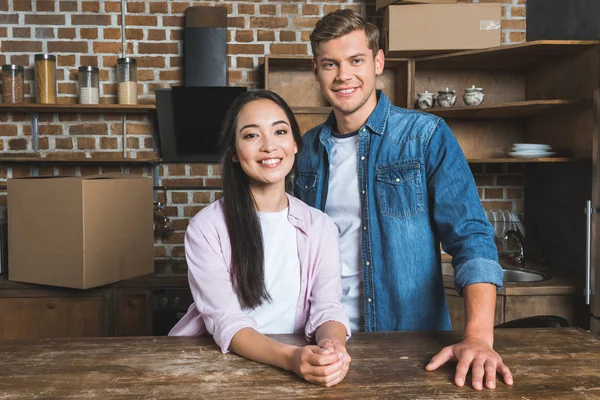 Feliz jovem casal de pé na cozinha da nova casa — Fotografia de Stock