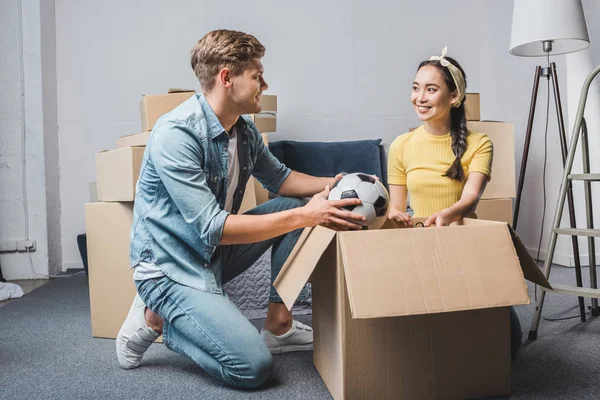 Jovem casal desempacotando caixas enquanto se move para nova casa — Fotografia de Stock