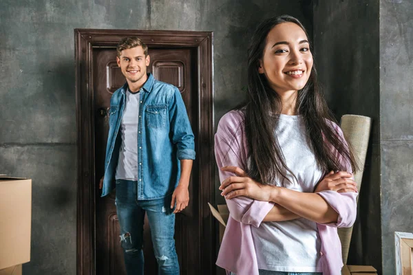 Interracial sonriente pareja mudándose en nuevo hogar - foto de stock