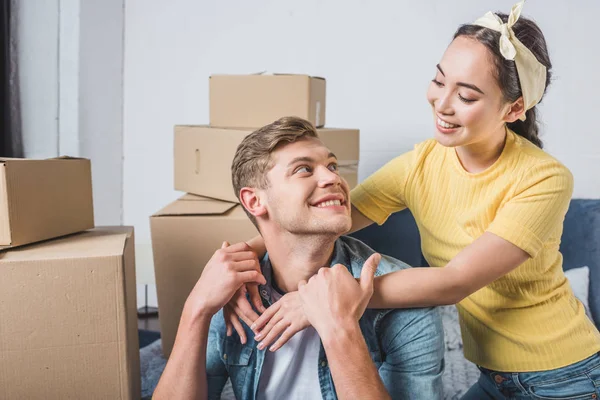 Schönes gemischtrassiges Paar, das sich beim Einzug in ein neues Zuhause umarmt — Stockfoto