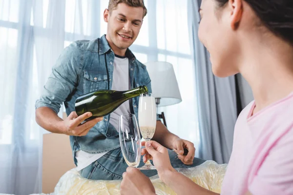 Schönes junges Paar trinkt Champagner beim Einzug in neues Zuhause — Stockfoto