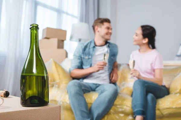 Belo jovem casal comemorando se mudar para nova casa com champanhe — Fotografia de Stock