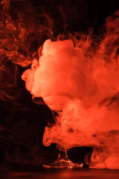 Orange creativity smoke in glass on black background — Stock Photo