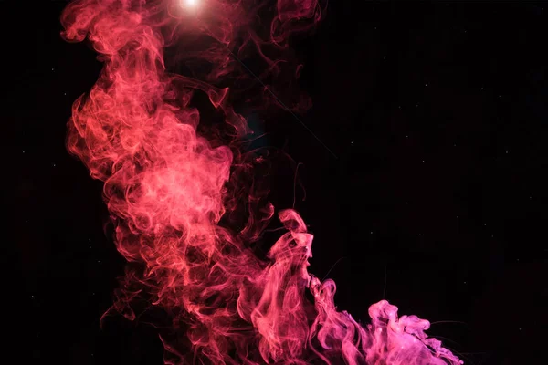 Pink spiritual smoky swirl with light on black background — Stock Photo