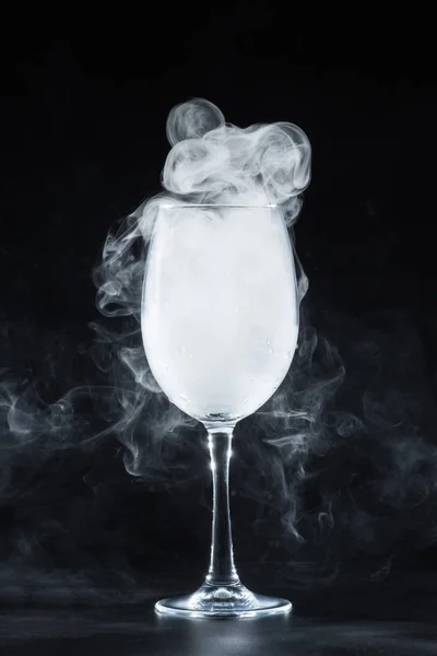 Fumée blanche dans un verre à vin sur fond noir — Photo de stock