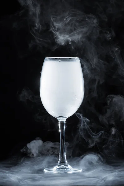 Vinho com fumaça branca sobre fundo preto — Fotografia de Stock