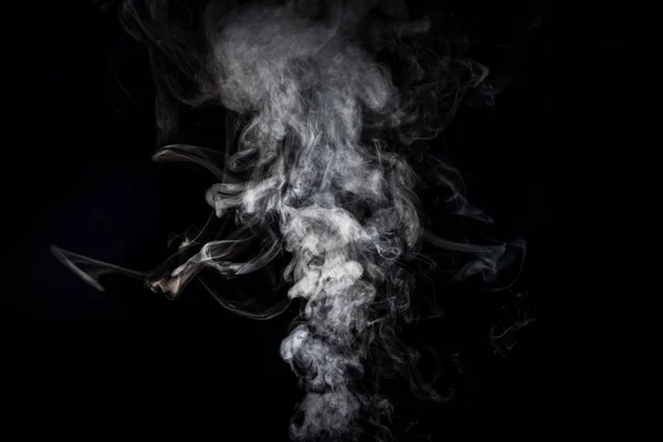 Серый дымный вихрь от сигареты на черном — стоковое фото