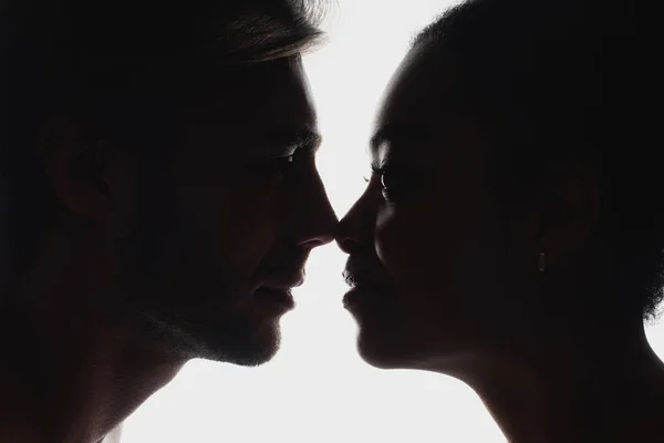 Vue latérale de silhouettes de couple interracial amoureux se regardant — Photo de stock