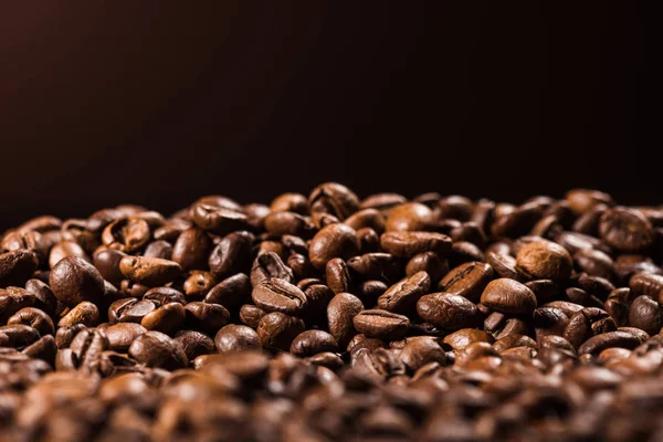 Close-up tiro de montão de grãos de café torrados isolados em preto — Fotografia de Stock