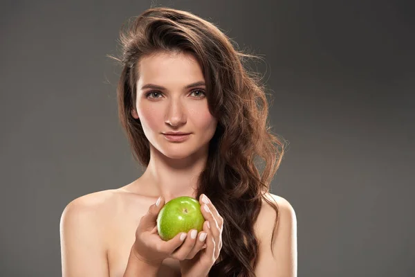 Hermosa chica morena con manzana verde fresca, aislado en gris - foto de stock