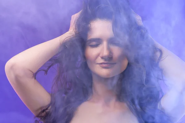 Retrato de chica desnuda bonita con los ojos cerrados en humo sobre púrpura - foto de stock
