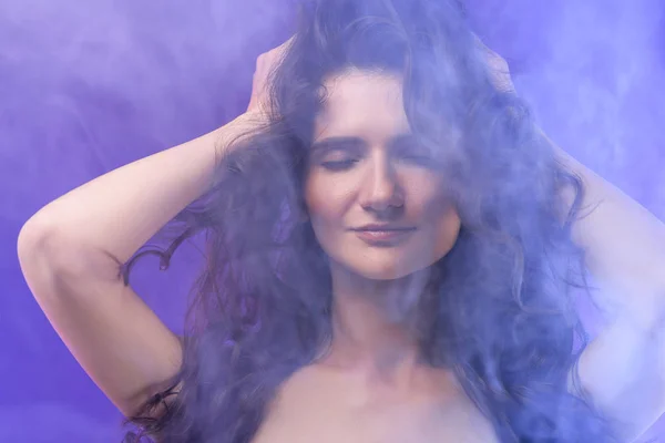 Portrait of pretty naked girl with closed eyes in smoke on purple — Stock Photo