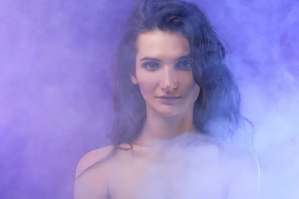 Portrait of nude elegant girl in smoke on purple — Stock Photo