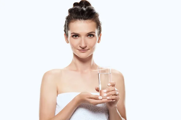 Красива дівчина в рушнику тримає склянку води, ізольована на білому — стокове фото