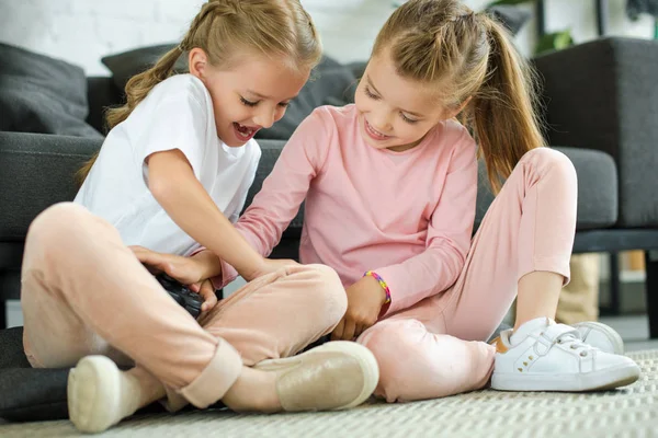 Kleine Schwestern mit Gamepad spielen zu Hause zusammen Videospiel — Stockfoto