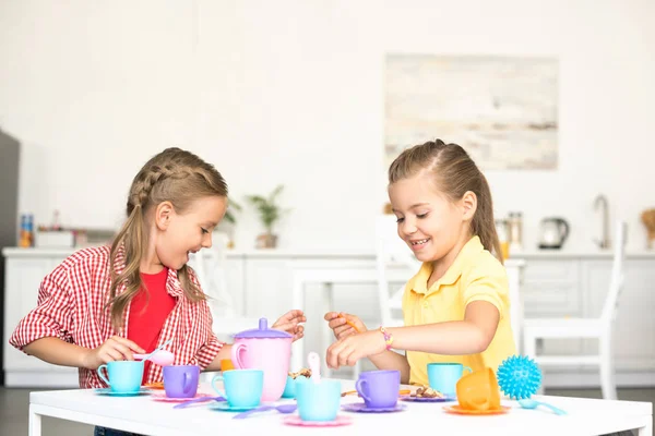 Cute little sisters pretending to have tea party together at home — Stock Photo
