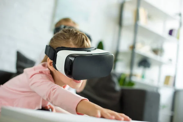 Vue obscurcie du petit enfant dans le casque de réalité virtuelle à la maison — Photo de stock