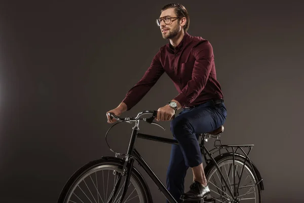 Bonito jovem no óculos andar de bicicleta no preto — Fotografia de Stock
