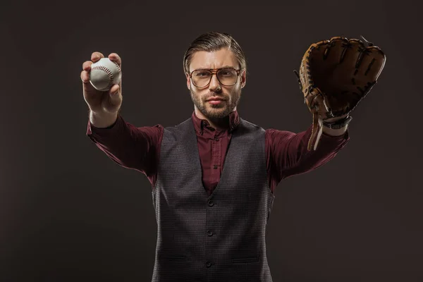 Serious man in eyeglasses holding baseball ball and looking at camera isolated on black — Stock Photo
