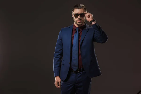 Guapo y elegante hombre de negocios con gafas de sol aisladas en negro - foto de stock