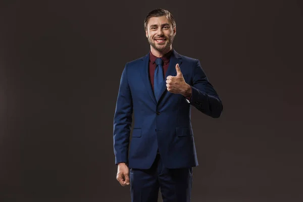 Homem de negócios feliz mostrando polegar para cima e sorrindo para a câmera isolada em preto — Fotografia de Stock