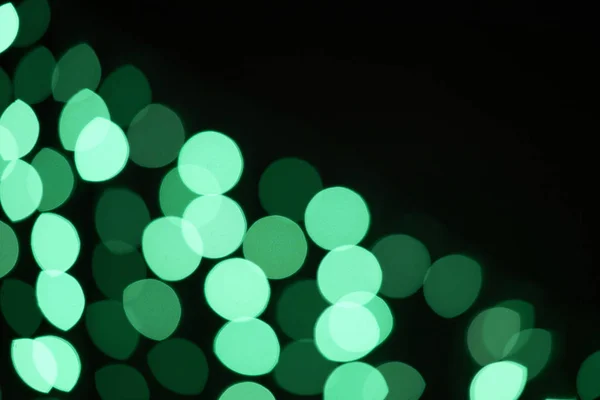 Beau bokeh vert brillant déconcentré sur fond noir — Photo de stock