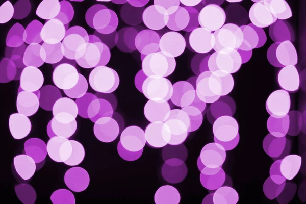 Beautiful shiny purple defocused bokeh on black background — Stock Photo