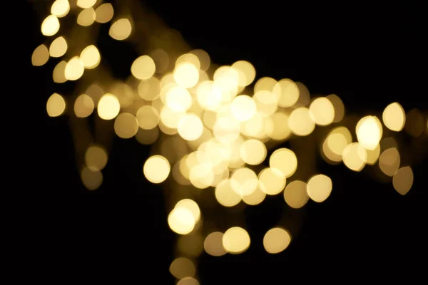 Belo bokeh dourado desfocado no fundo preto — Fotografia de Stock