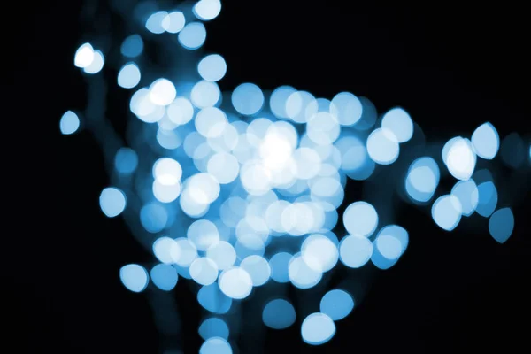 Schöne glänzende blaue Bokeh auf schwarzem Hintergrund — Stockfoto