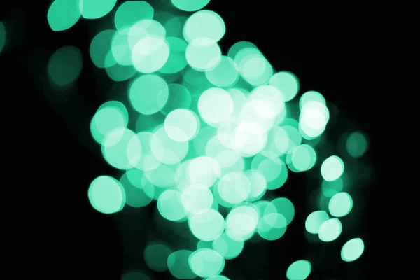 Beau bokeh vert déconcentré brillant sur fond noir — Photo de stock