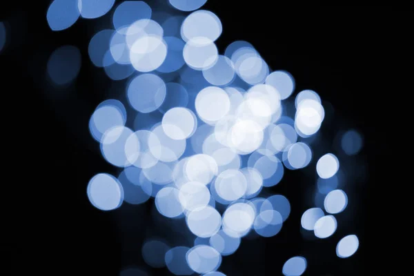 Beautiful shiny defocused blue bokeh on black background — Stock Photo