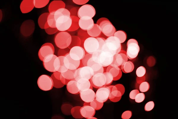 Bonito brilhante desfocado vermelho bokeh no fundo preto — Fotografia de Stock