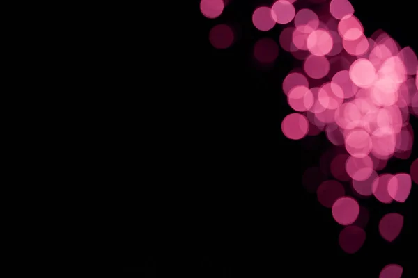 Beautiful pink shiny defocused bokeh on black background — Stock Photo