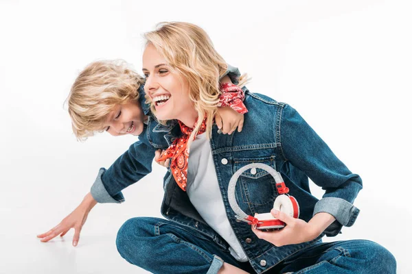 Mãe e filho se divertindo juntos e segurando fones de ouvido isolados no branco — Fotografia de Stock