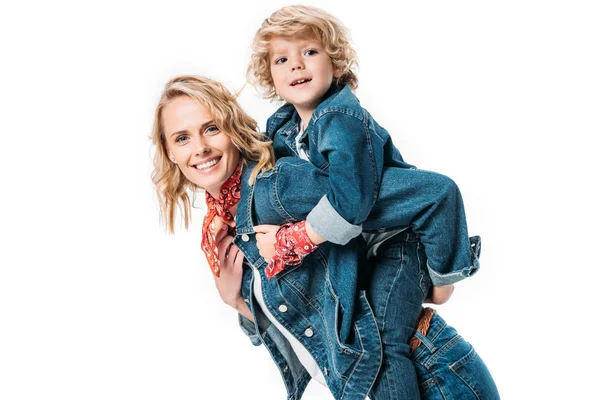 Happy mother having fun and giving piggyback to son isolated on white — Stock Photo