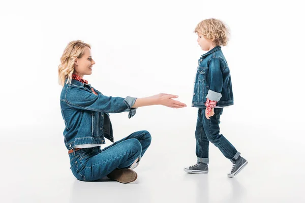 Seitenansicht des Sohnes, der zu Mama auf Weiß geht — Stockfoto