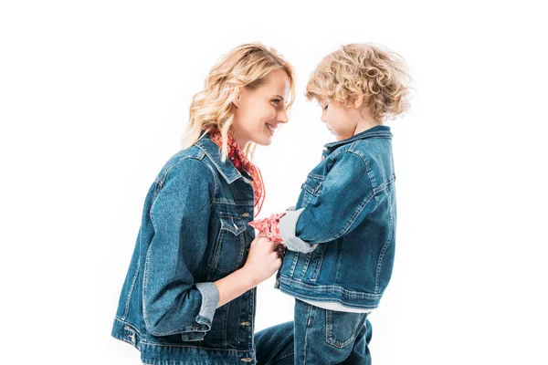 Vista lateral de sonriente madre e hijo tomados de las manos aislados en blanco - foto de stock