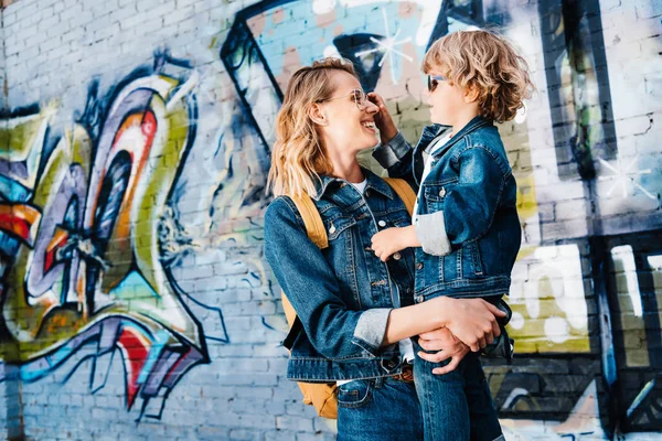 Mãe feliz segurando filho e eles olhando um para o outro na rua — Fotografia de Stock