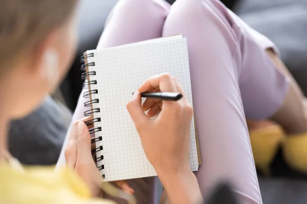 Enfoque selectivo de la mujer escribiendo en un libro de texto vacío - foto de stock