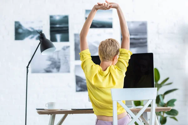 Rear view of businesswoman doing stretch with two raised arms — Stock Photo