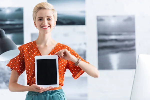 Lächelnde Frau präsentiert digitales Tablet mit leerem Bildschirm — Stockfoto