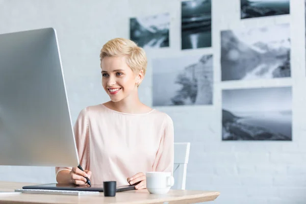 Glückliche Freiberuflerin zeichnet auf Grafik-Tablet am Tisch im Homeoffice — Stockfoto