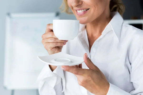 Geschnittenes Bild attraktiver Geschäftsfrau, die im Büro Kaffee trinkt — Stockfoto